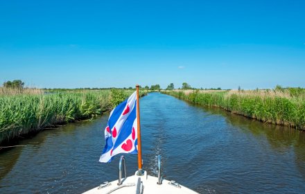 Cruising through National Park Alde Feanen in Friesland the Netherlands with the frisian flag