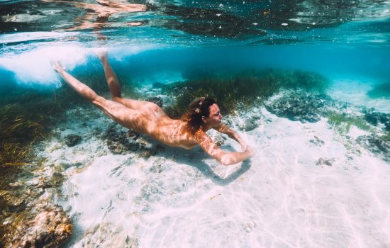 Attractive woman swimming and dive in tropical ocean, underwater photo
