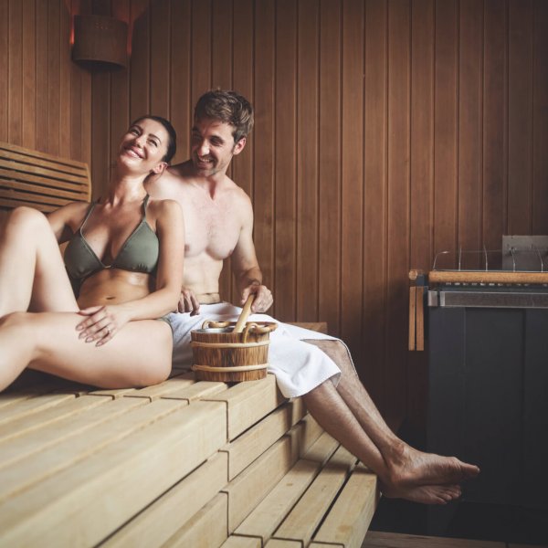 Beautiful couple relaxing in sauna and caring about health and skin