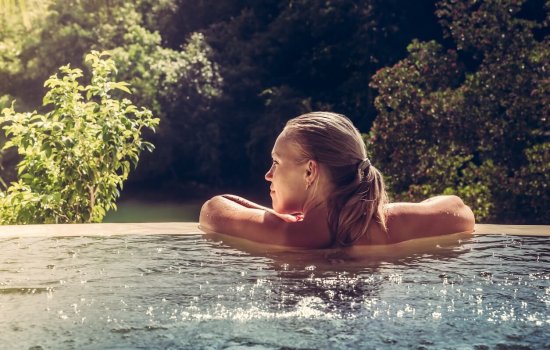 Woman relaxing in hotel  swimming pool looking at view
