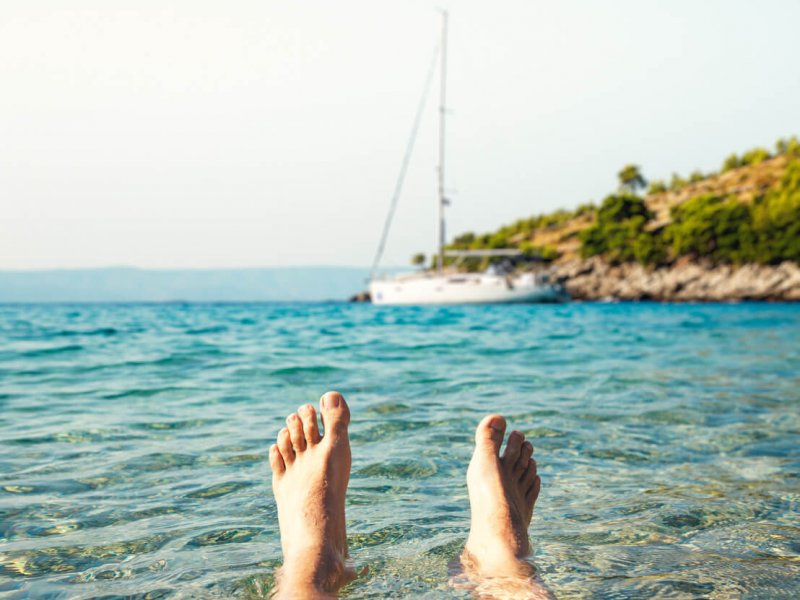 Man lying in the water enjoying summer vacations in remote bay on Brac island.