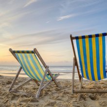 Two Deckchairs On A Beach